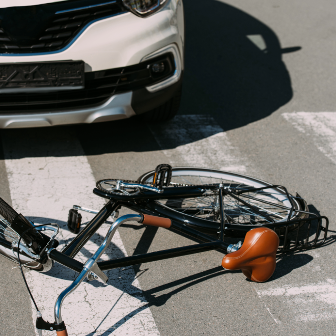 Crushed bicycle under the front bumper of a car