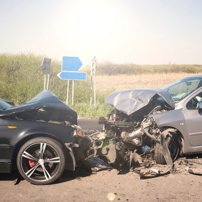 Black car with severe front-end damage after a commercial vehicle crash
