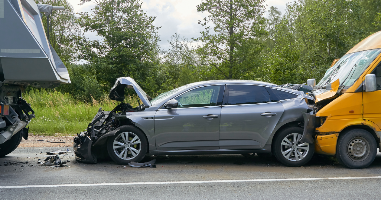 Car crushed between a delivery van and a truck
