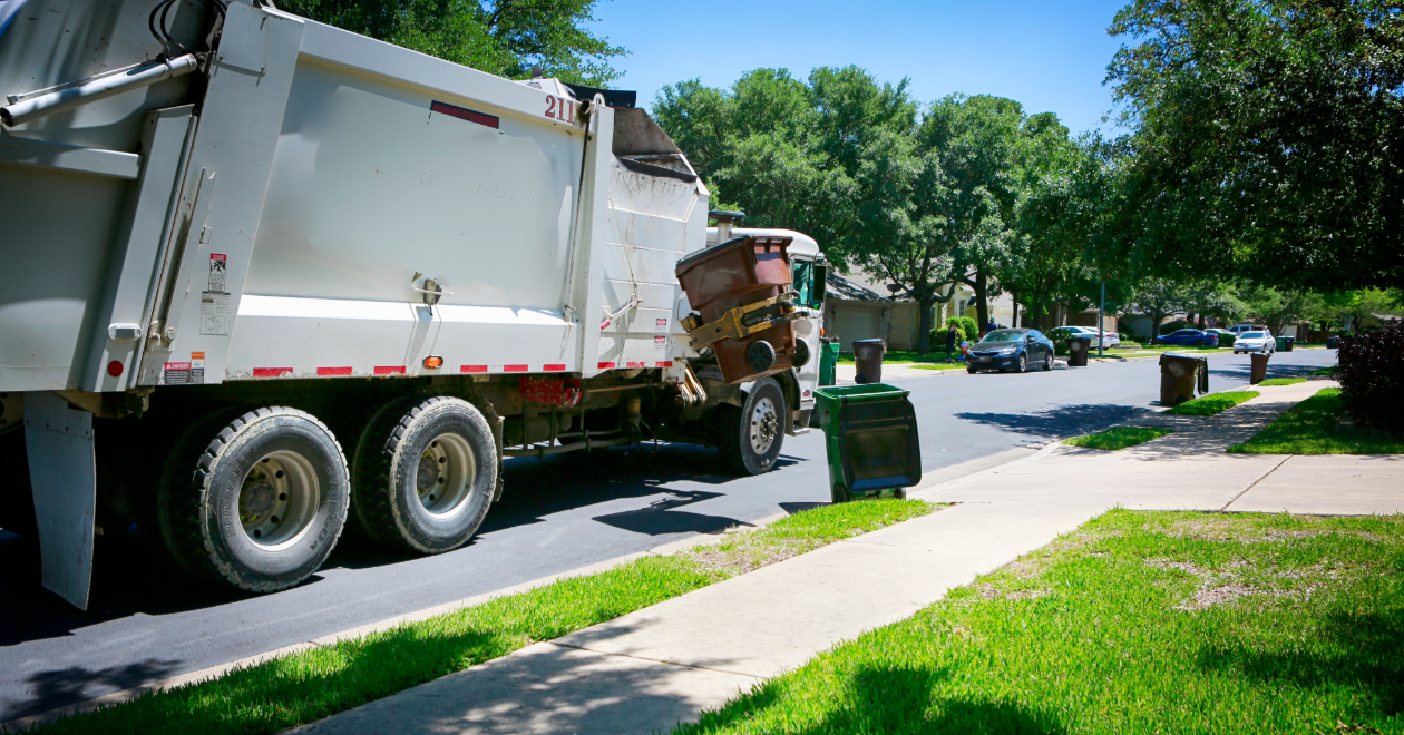 Rear-loading garbage truck on a neighborhood street