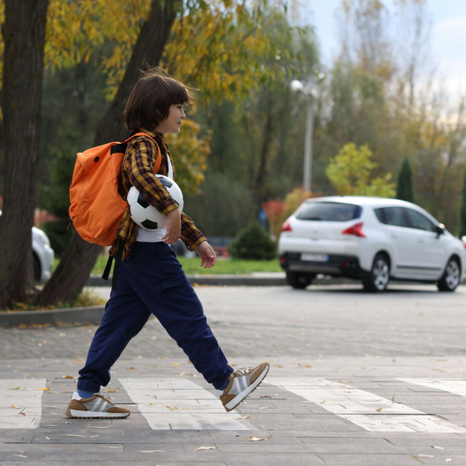 Pedestrian crossing the street near a car