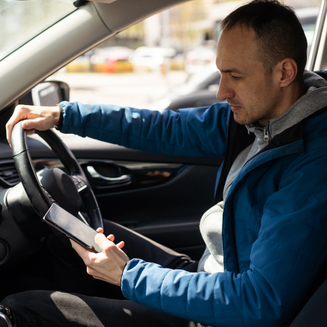 Distracted rideshare driver checking a phone