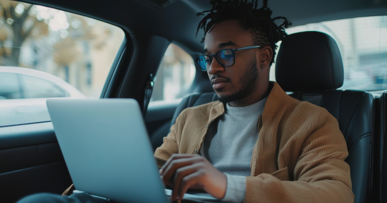 Passenger working on a laptop in a rideshare vehicle